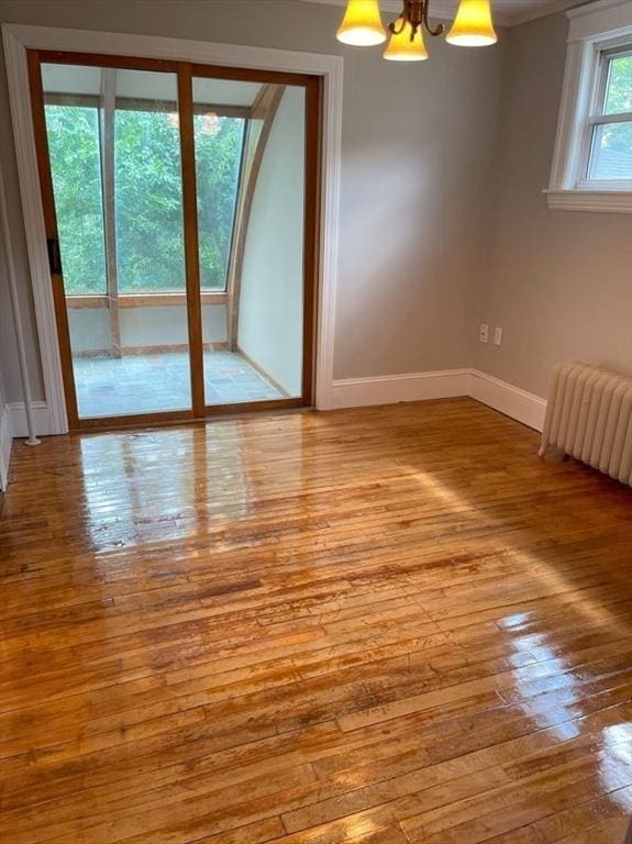 39 Barnard Rd, Worcester, MA 01605 - empty room featuring wood-type flooring, radiator heating unit, and a chandelier