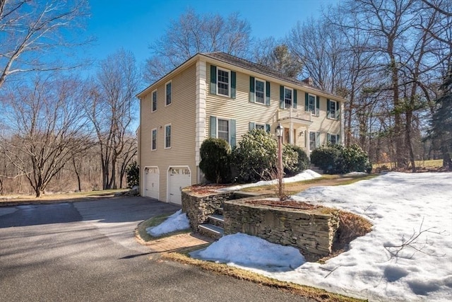 colonial-style house featuring driveway and a garage