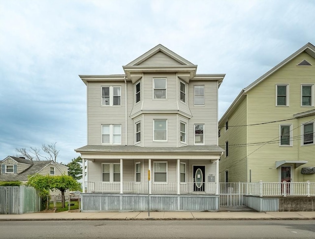 view of front facade with covered porch and fence