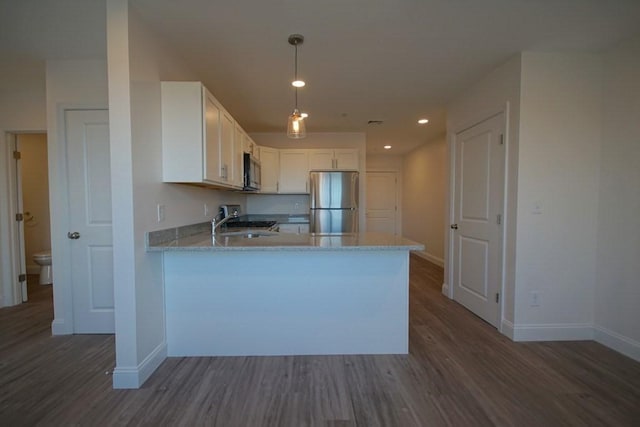 kitchen featuring freestanding refrigerator, dark wood-style flooring, a peninsula, and stove