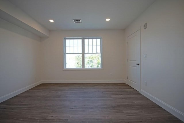 unfurnished room featuring recessed lighting, wood finished floors, visible vents, and baseboards