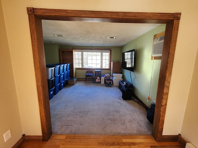 living room with carpet floors and an AC wall unit