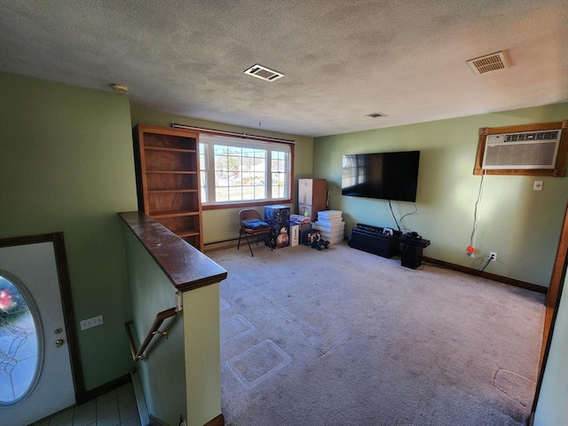 interior space featuring a wall unit AC, light colored carpet, a textured ceiling, and a baseboard heating unit