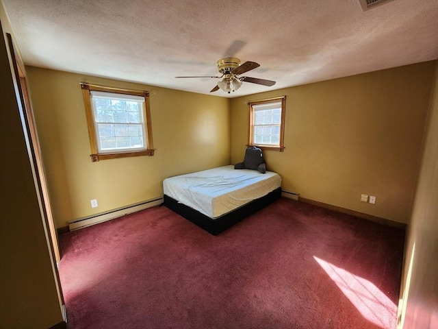 unfurnished bedroom featuring dark colored carpet, baseboard heating, and ceiling fan