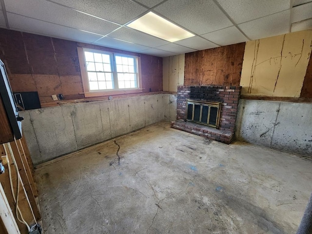 interior space with a paneled ceiling and a fireplace