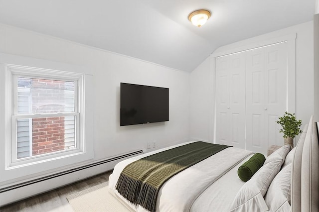 123 Ash St, New Bedford, MA 02740 - bedroom featuring baseboard heating, lofted ceiling, a closet, and wood finished floors