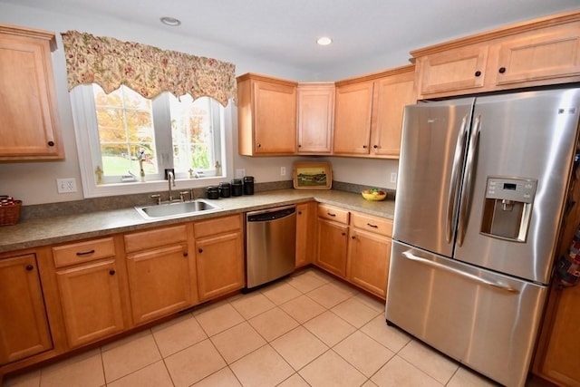 kitchen featuring appliances with stainless steel finishes, light tile patterned floors, and sink