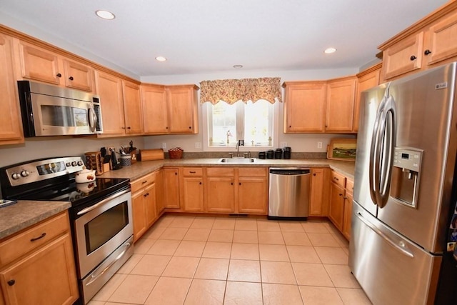 kitchen with stainless steel appliances, light tile patterned floors, and sink