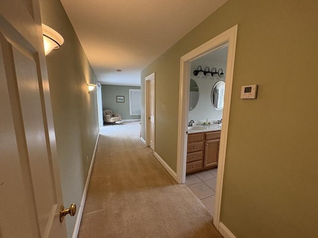 hall featuring sink and light carpet