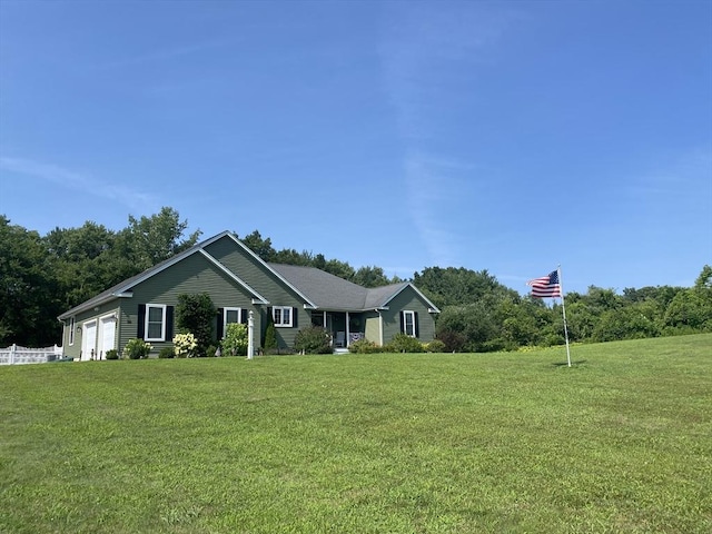 ranch-style house featuring a garage and a front lawn