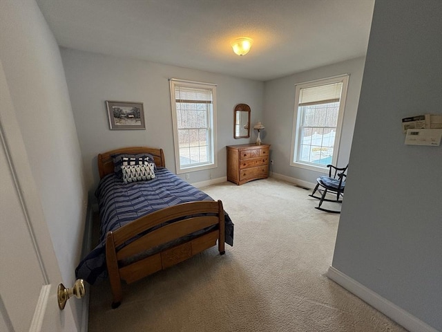 bedroom featuring light carpet and multiple windows