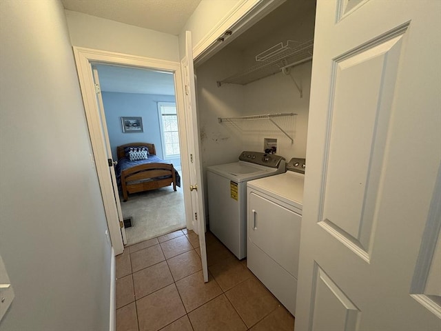 laundry room with separate washer and dryer and light tile patterned floors