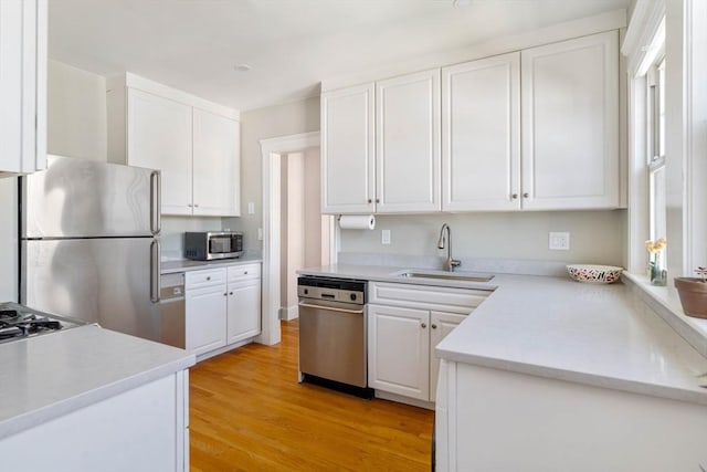 42 Lourdes Ave Unit 3, Boston, MA 02130 - kitchen with appliances with stainless steel finishes, white cabinetry, light wood finished floors, and light countertops