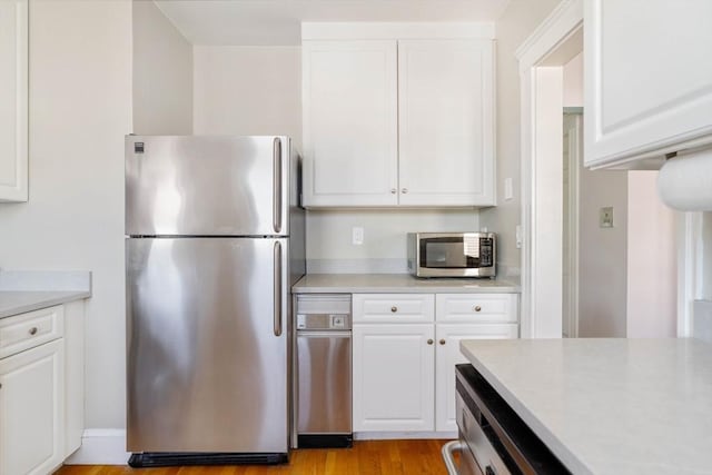 42 Lourdes Ave Unit 3, Boston, MA 02130 - kitchen with appliances with stainless steel finishes, light countertops, white cabinetry, and light wood-type flooring