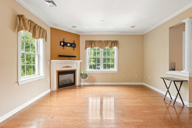 190 Chickering Rd Unit 201D, North Andover, MA 01845 - unfurnished living room featuring wood finished floors, a glass covered fireplace, ornate columns, baseboards, and ornamental molding