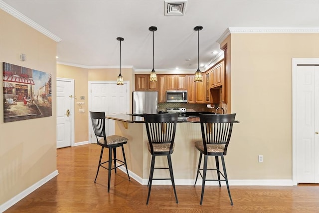 190 Chickering Rd Unit 201D, North Andover, MA 01845 - kitchen with stainless steel appliances, a peninsula, light wood-style flooring, tasteful backsplash, and ornamental molding