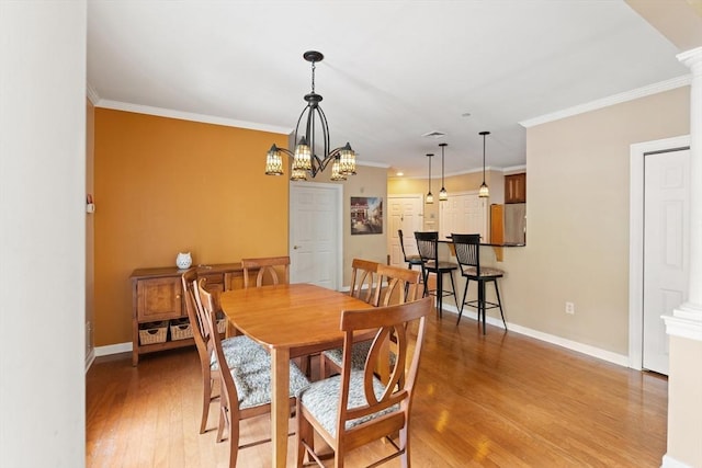 190 Chickering Rd Unit 201D, North Andover, MA 01845 - dining room featuring light wood-type flooring, decorative columns, ornamental molding, baseboards, and a chandelier