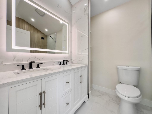 full bathroom with marble finish flooring, toilet, baseboards, double vanity, and lofted ceiling
