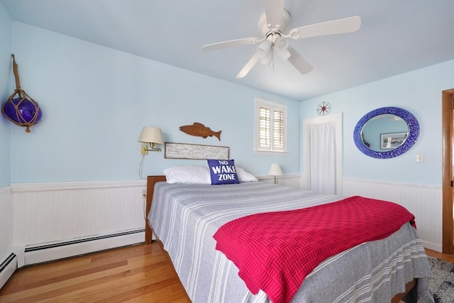 36 Ocean St, Marshfield, MA 02050 - bedroom with wood finished floors, wainscoting, a baseboard heating unit, and ceiling fan