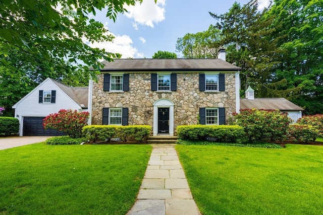 23 Ascenta Ter, Newton, MA 02465 - colonial-style house with stone siding, a chimney, a front lawn, a garage, and driveway