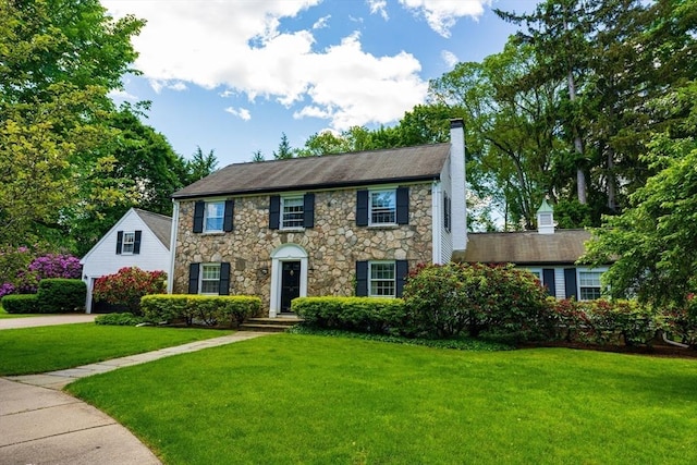 23 Ascenta Ter, Newton, MA 02465 - colonial home featuring stone siding, a chimney, and a front yard