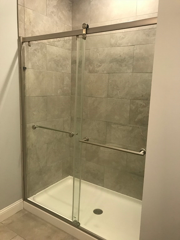 bathroom with tile flooring and an enclosed shower