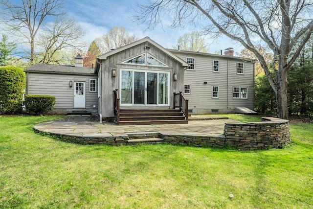 rear view of property with a lawn, a chimney, a patio area, and entry steps
