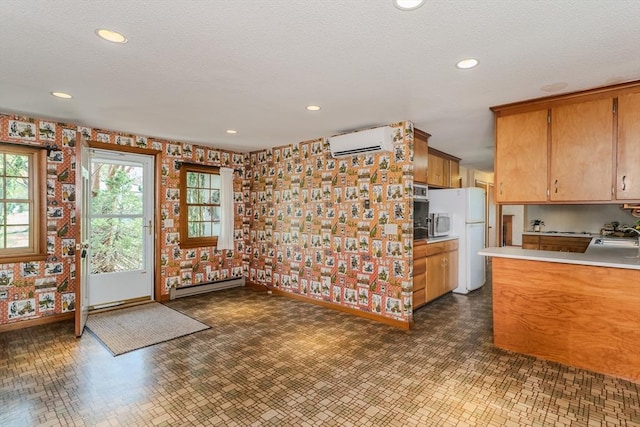 kitchen with baseboards, baseboard heating, wallpapered walls, light countertops, and a wall mounted AC