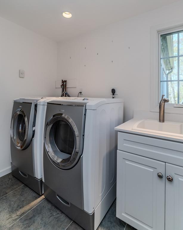 washroom with cabinet space, recessed lighting, washing machine and dryer, and a sink