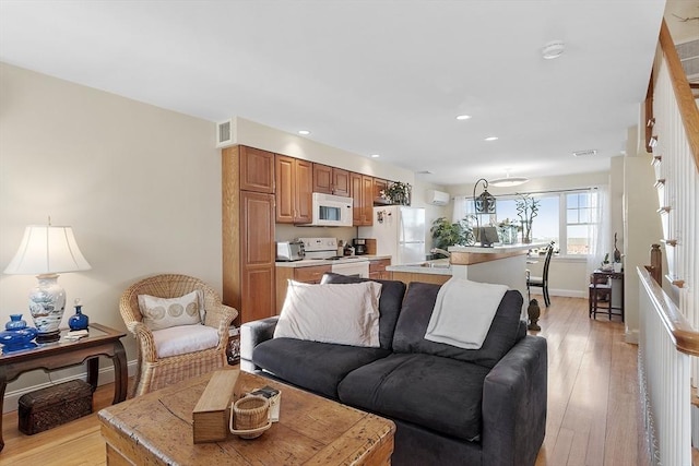 living area featuring baseboards, recessed lighting, visible vents, and light wood-style floors