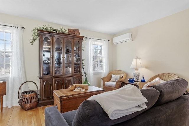 living area featuring an AC wall unit and light wood-style flooring