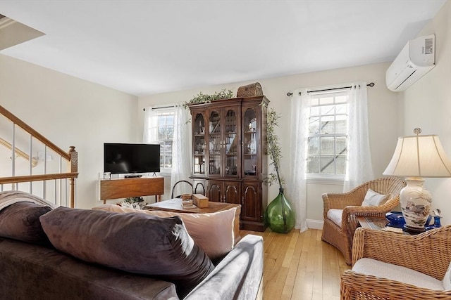 living area with light wood-type flooring and a wall mounted AC