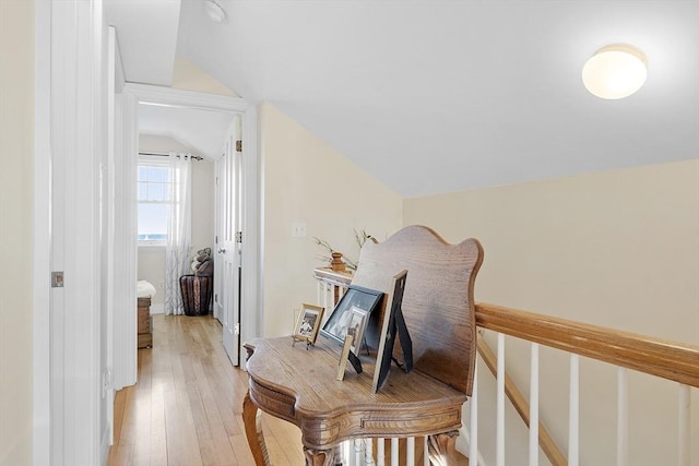 hall with lofted ceiling and light wood finished floors