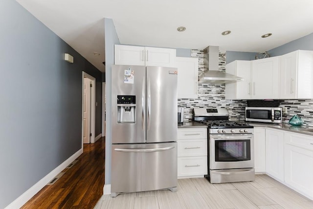 11 Ann Ave, Dartmouth, MA 02747 - kitchen featuring stainless steel appliances, wall chimney range hood, backsplash, white cabinetry, and dark countertops