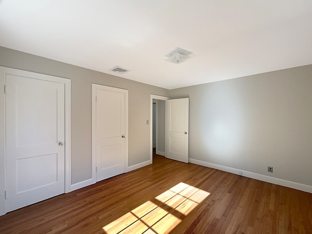 unfurnished bedroom with hardwood / wood-style flooring