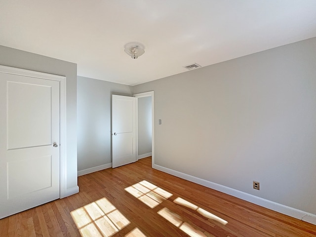 unfurnished bedroom featuring a closet and light hardwood / wood-style floors