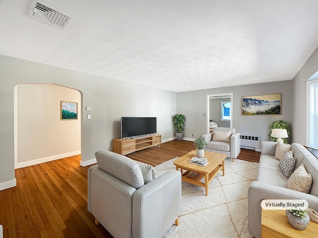 living room with radiator and wood-type flooring