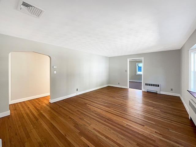 spare room featuring hardwood / wood-style floors, radiator heating unit, and a baseboard heating unit