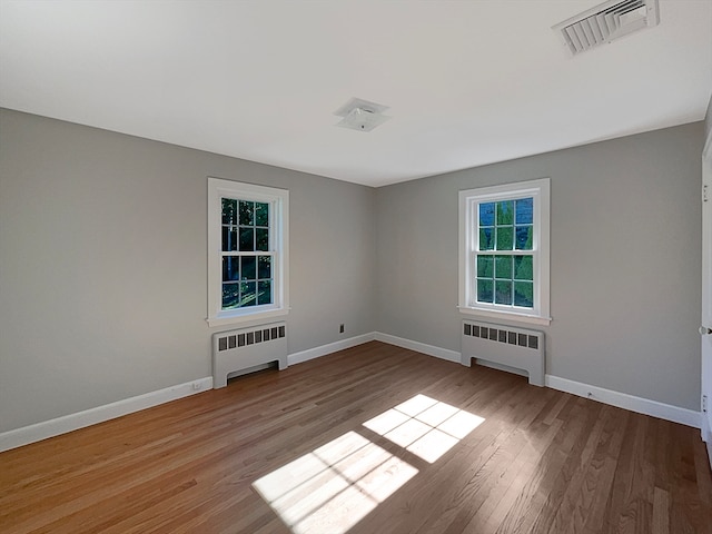 spare room with light wood-type flooring and radiator