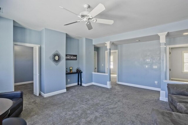 living area with visible vents, baseboards, ceiling fan, carpet floors, and ornate columns