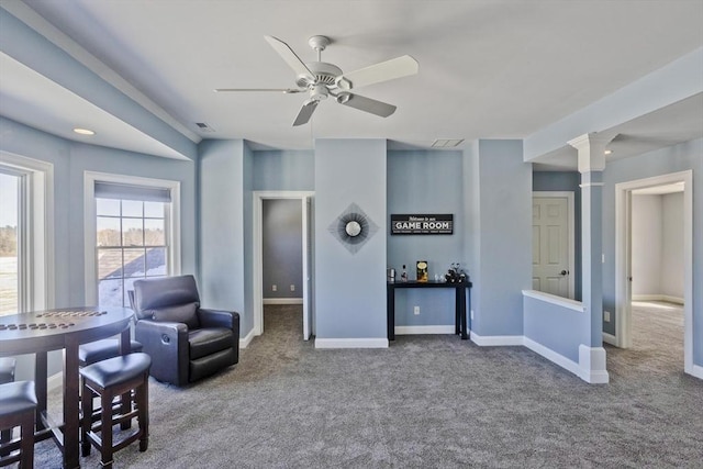 living area with carpet floors, baseboards, ornate columns, and a ceiling fan