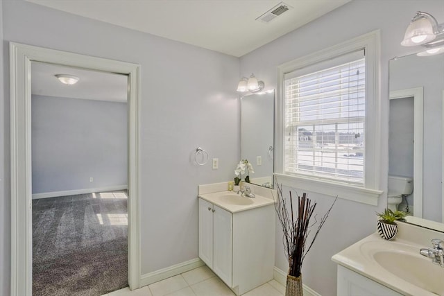 full bath featuring toilet, vanity, visible vents, and baseboards