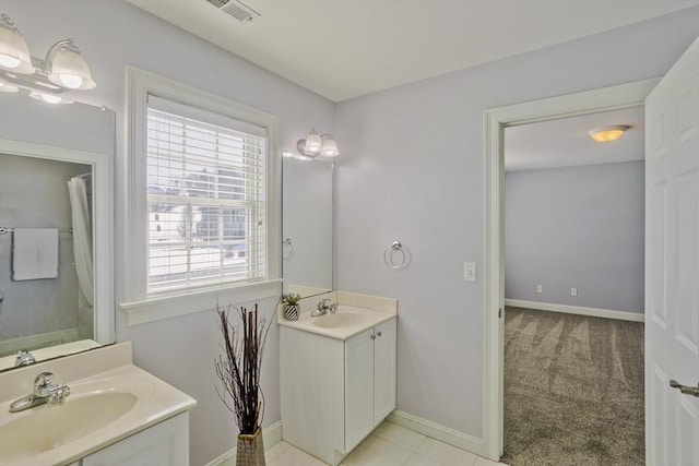 bathroom with two vanities, visible vents, a sink, and baseboards