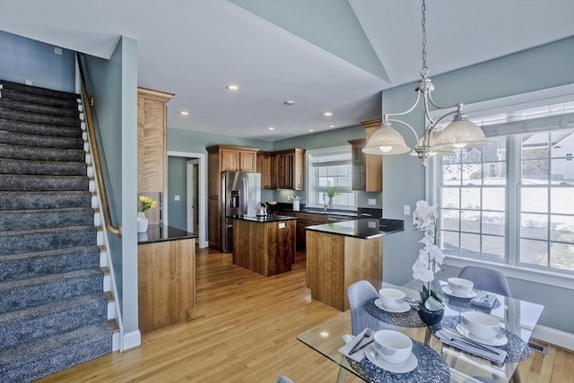 dining area with lofted ceiling, stairway, light wood-style floors, a notable chandelier, and recessed lighting