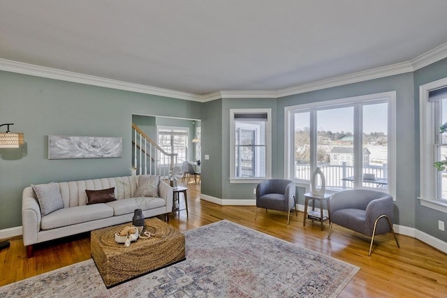 living area featuring stairs, ornamental molding, wood finished floors, and baseboards