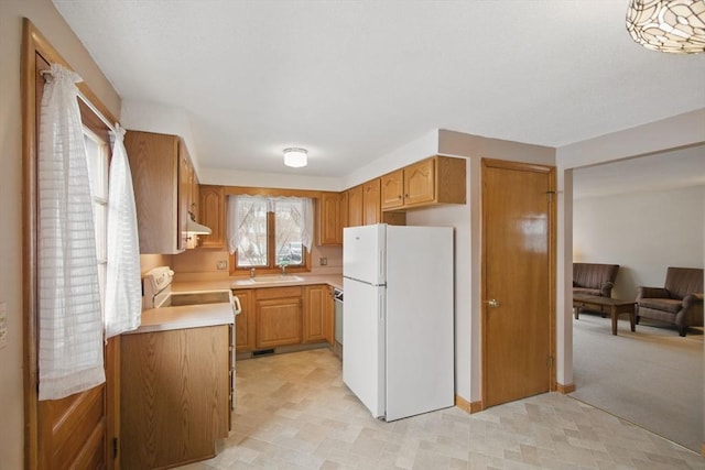 kitchen featuring under cabinet range hood, white appliances, a sink, visible vents, and light countertops