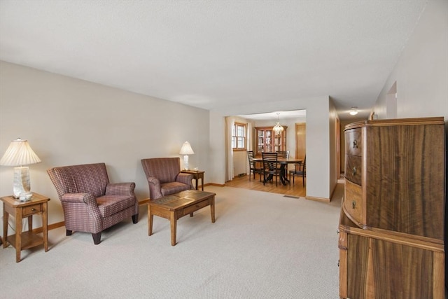 sitting room featuring light carpet and baseboards