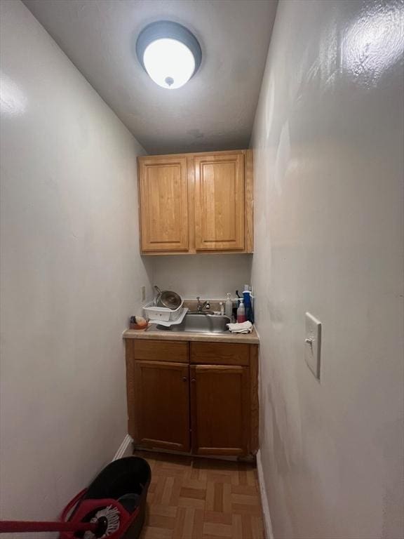 bar featuring baseboards and a sink