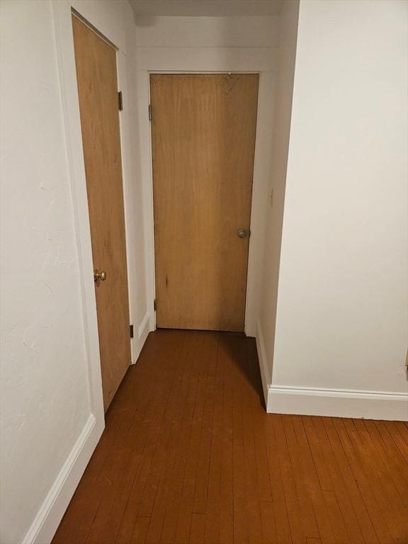 hallway with baseboards and wood finished floors