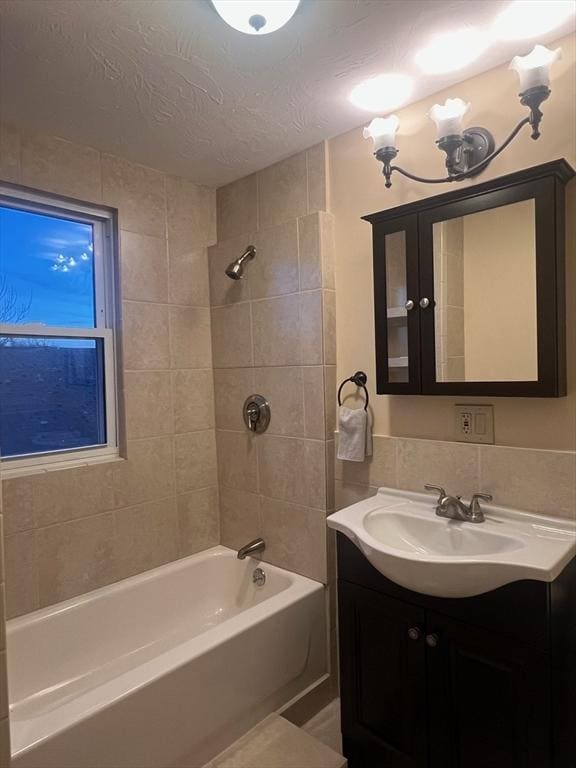 full bathroom with bathtub / shower combination, a textured ceiling, and vanity